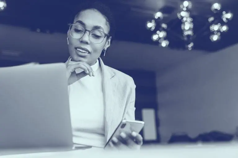 Professional woman working on a laptop and mobile phone. Interpreter services.